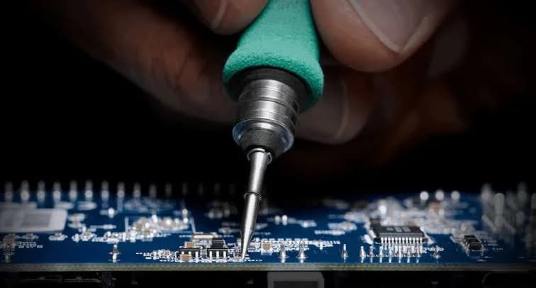 Soldering iron tip working on a circuit board
