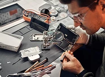Heat gun and tweezers used on a phone circuit board